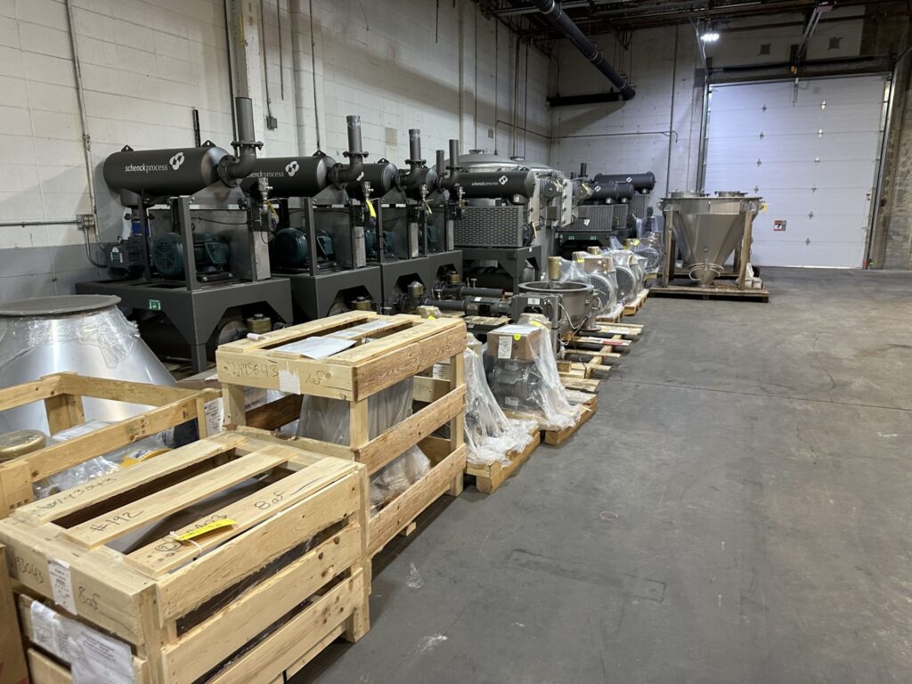 A warehouse filled with various industrial machines and stacked pallets